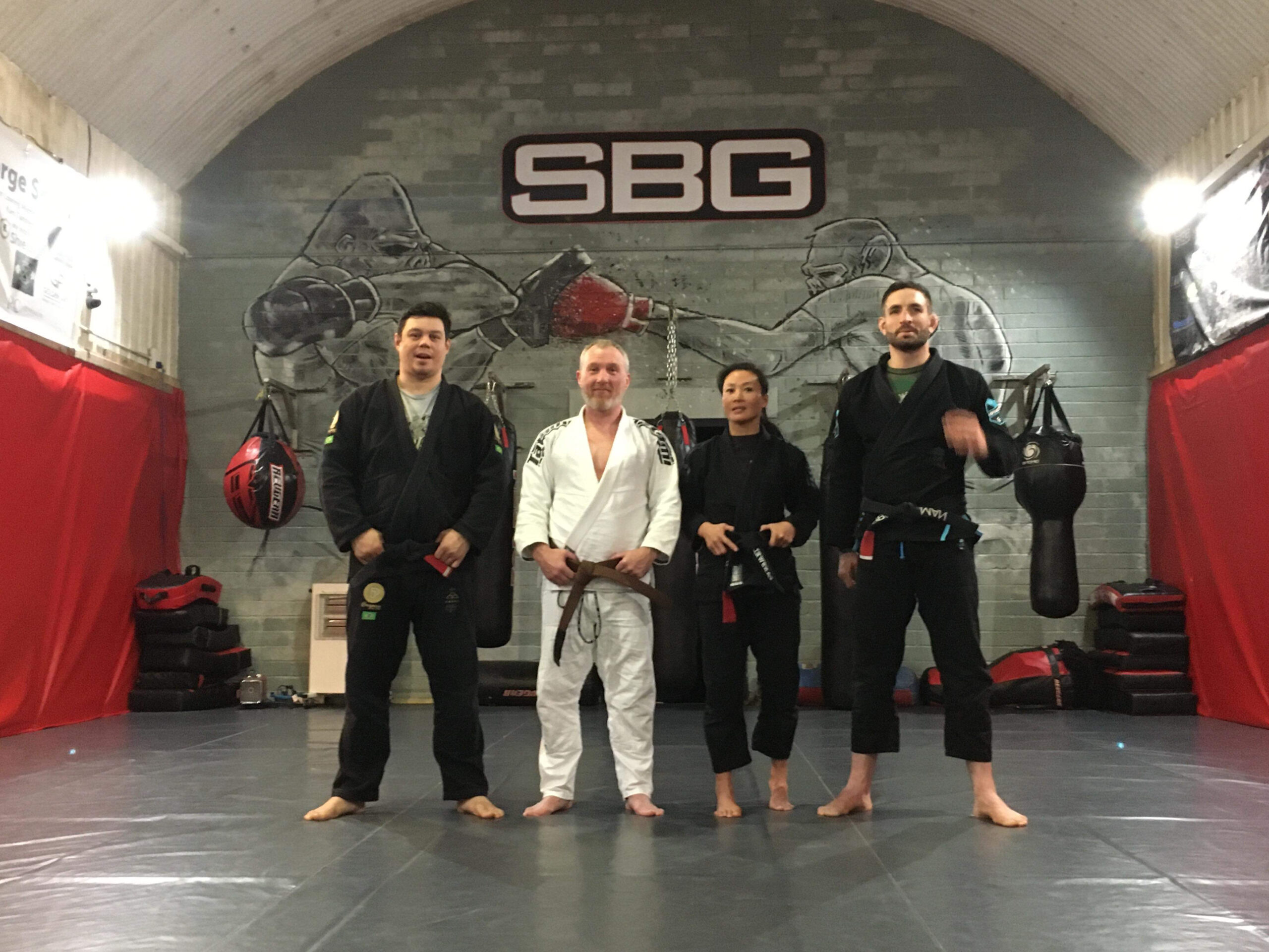 Simon in his white gi with teammates at his brown belt promotion