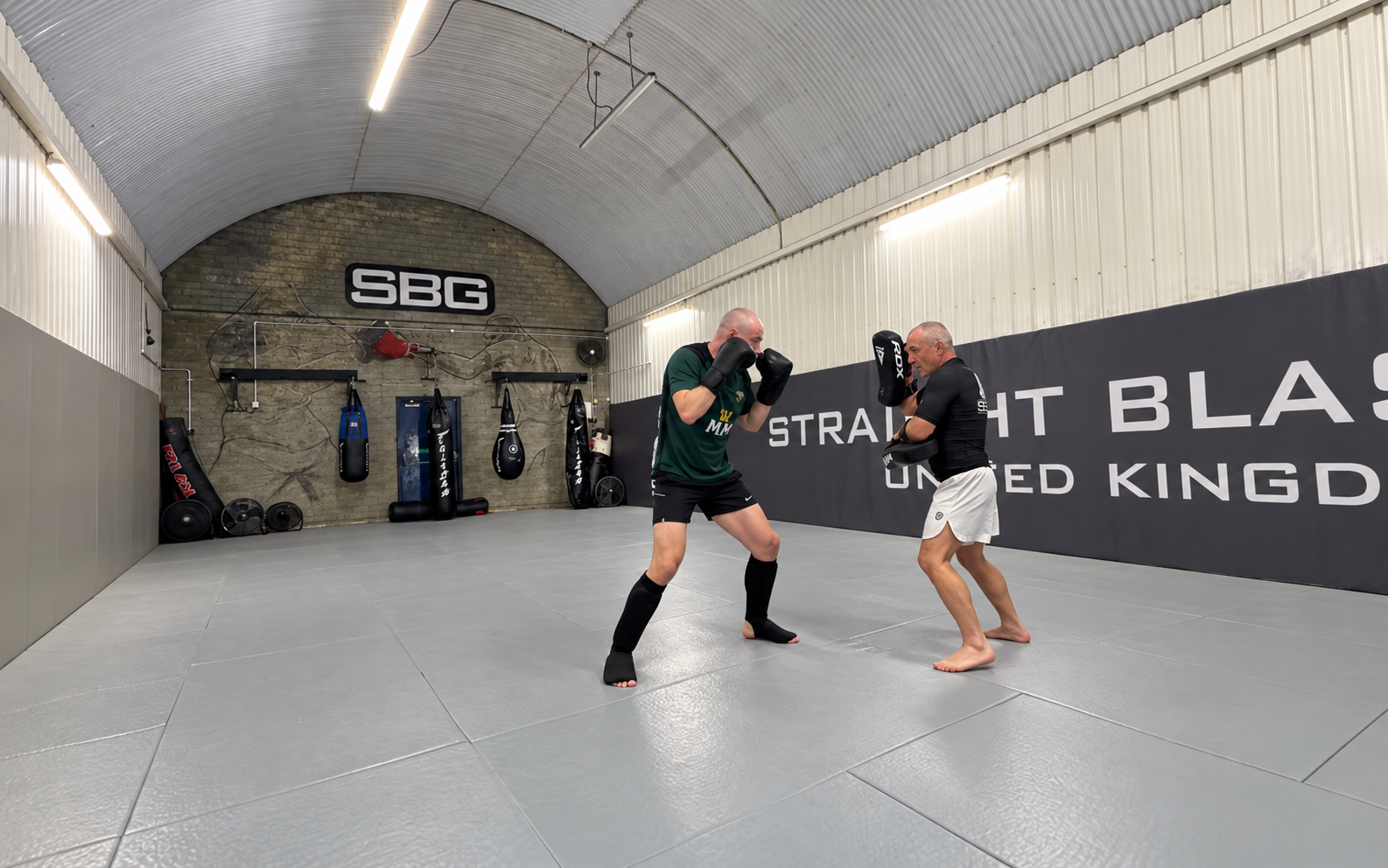 Simon Kenny holding pads during a private striking session at SBG Manchester